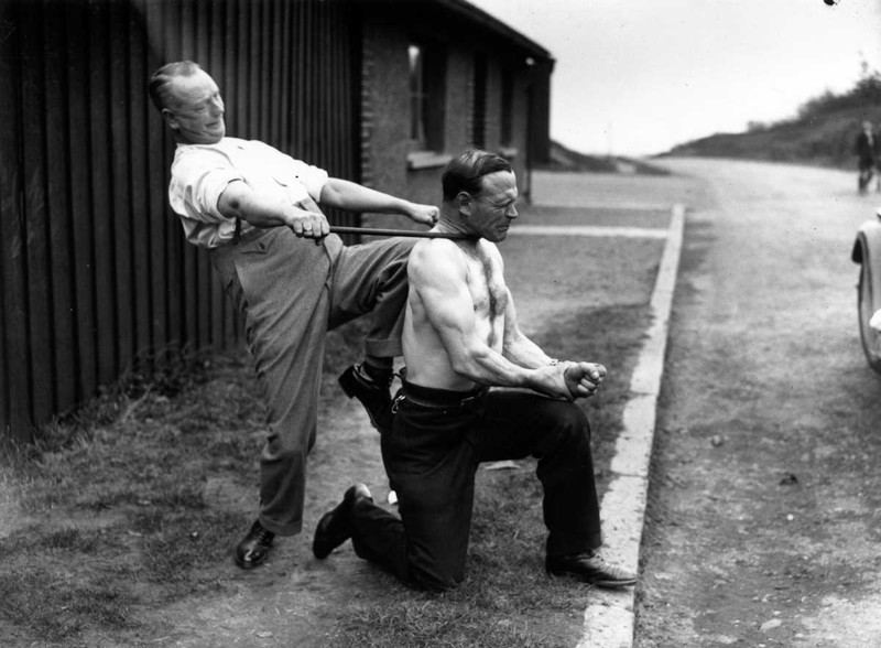 18 марта 1935 года. Лондонский силач Джордж Чаллард позволяет напарнику согнуть металлическую трубу вокруг шеи. история, люди, сила